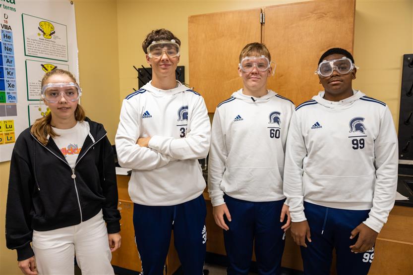Four students smile in a lab